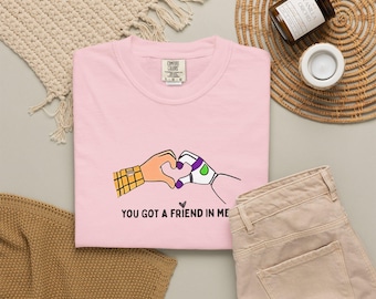 Camisetas Comfort Colors® con estampado de Toy Story y sus amigos, camiseta con el mensaje "Tienes un amigo en mí" y manos en forma de corazón.