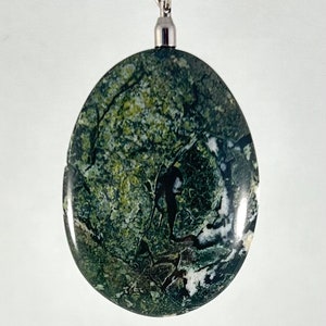 Peut inclure: Un pendentif ovale vert, blanc et noir avec un fermoir argenté.