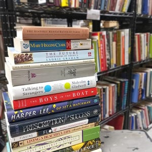 May include: A white ceramic mug with a black handle and the text "But First, Coffee" in a black, bold font. The mug is on a white surface.