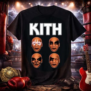 May include: Black t-shirt featuring the word "KITH" in white block letters above four images of faces with makeup. The background includes boxing equipment and a red electric guitar.