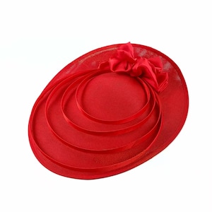 Peut inclure: Un chapeau de c&eacute;r&eacute;monie rouge vif avec un grand n&oelig;ud et un ruban d&eacute;coratif. Le chapeau a un large bord et un rev&ecirc;tement en r&eacute;sille, id&eacute;al pour les occasions sp&eacute;ciales.