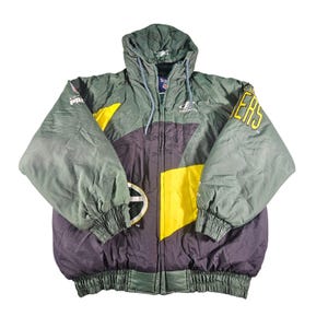 May include: A hooded, green, yellow, and purple jacket with the word "Packers" on the sleeve. The jacket has a zipper closure and a drawstring hood. The jacket has a logo on the front and the sleeves.