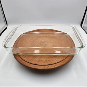 Puede incluir: Una fuente de horno rectangular de vidrio transparente con asas integradas en los lados cortos. El fondo de la fuente presenta un texto en relieve que dice Pyrex, Made in USA, e incluye un número, visible a través de la base de vidrio.