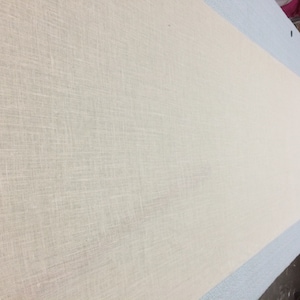 May include: A close-up of a white fabric with a subtle woven texture.