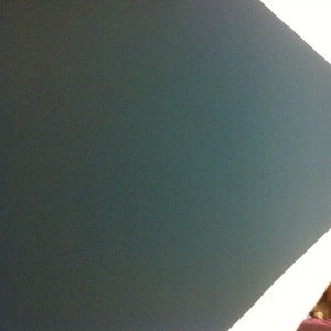 May include: A dark green felt surface, possibly a pool table or game table.