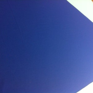 May include: A close-up of a blue fabric surface with a light blue triangle in the upper left corner.