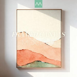 Puede incluir: Un lienzo enmarcado vertical que presenta un paisaje abstracto en acuarela con colinas superpuestas en tonos crema, melocotón, terracota y verde apagado. El texto FRAMED CANVAS MOCKUP está centrado sobre la obra en una fuente serif blanca.