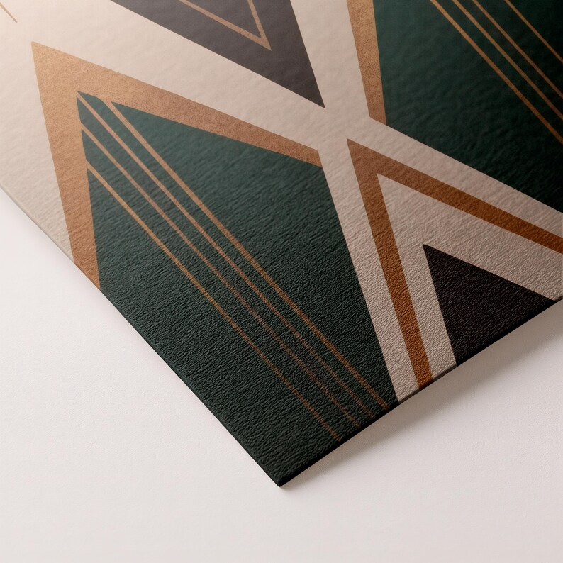 May include: Close-up of a geometric design with a textured surface. The design features dark green, tan, and bronze-colored shapes, including triangles and lines. The artwork has a modern, art deco style.