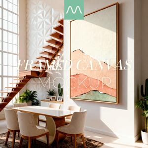 以下が含まれることがあります： 桃色、緑色、ベージュの色合いの水彩画の風景画が描かれた、額縁に入ったキャンバスのモックアップ。 ダイニングテーブル、椅子、木製の階段を備えたモダンなインテリアにアートワークが展示されています。 テキスト「FRAMED CANVAS MOCKUP」が画像に重ねられています。