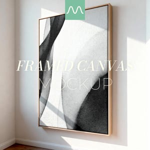 Puede incluir: Una maqueta de lienzo enmarcado con un diseño abstracto en blanco y negro. La obra de arte se muestra en un marco de madera clara, contra una pared blanca. El texto "FRAMED CANVAS MOCKUP" está superpuesto en la imagen.