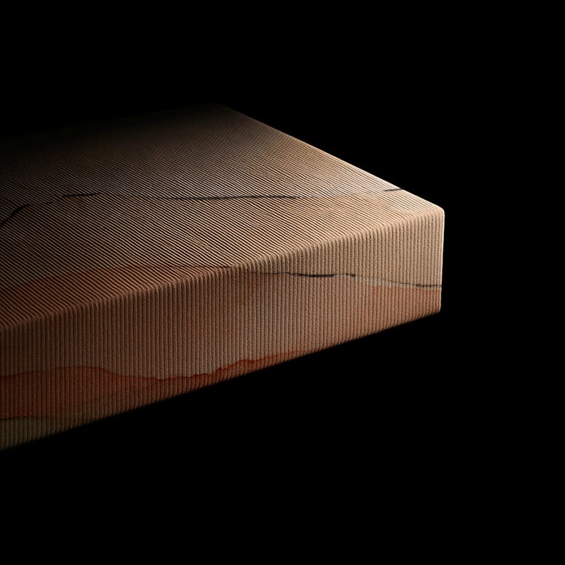Puede incluir: Un bloque rectangular con una superficie texturizada y acanalada con l&iacute;neas horizontales. El objeto muestra un degradado de tonos beige, marr&oacute;n claro y naranja terracota con finas grietas horizontales oscuras e irregulares.