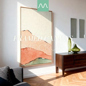 May include: A vertical framed canvas featuring an abstract landscape painting with layered horizontal bands of cream, peach, and muted green colors. The artwork is displayed on a white wall above a dark wooden sideboard with two green glass vases.