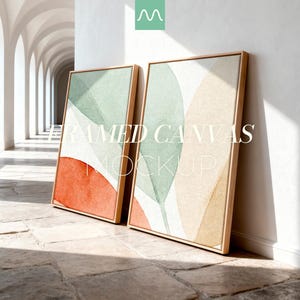 May include: Two vertical rectangular canvases in light wood frames featuring abstract leaf shapes in muted sage green, terracotta orange, and beige. The text FRAMED CANVAS MOCKUP is overlaid in white across the centre of the two art pieces.