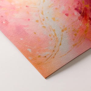 May include: Abstract art print featuring a watercolor design with a gradient of pink, peach, and orange hues. Gold accents and small red details add visual interest. The textured surface adds depth to the artwork.
