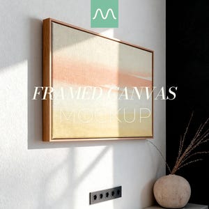 以下が含まれることがあります： 明るい木製フレームの額入りキャンバスモックアップ。キャンバスは、黄色から桃色へと変化する色のグラデーションが特徴です。「FRAMED CANVAS MOCKUP」の文字が繊細なフォントで表示されています。