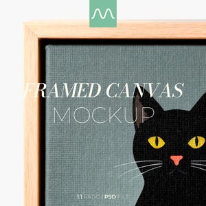 May include: A framed canvas mockup featuring a black cat illustration with yellow eyes and a pink nose against a muted blue-gray background. The artwork is encased in a light-colored wooden frame. The text reads FRAMED CANVAS MOCKUP.