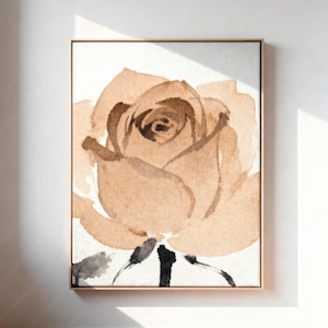May include: A rectangular wall art print featuring a watercolor painting of a single rose in shades of tan, beige, and brown. The flower is centered on a white background with dark brown and black brushstrokes defining the stem and leaves.