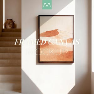 May include: A rectangular framed canvas featuring an abstract desert landscape with terracotta and beige sand dunes. The artwork is displayed on a plain wall with text overlay reading FRAMED CANVAS MOCKUP and a small green logo at the top center.
