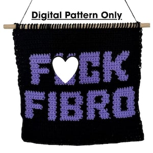 Puede incluir: Un tapiz de ganchillo negro con el texto morado FCK FIBRO y un corazón blanco que sustituye a la letra U. La pieza cuelga de un palo de madera clara con un cordel negro. El texto Digital Pattern Only es visible en la imagen.