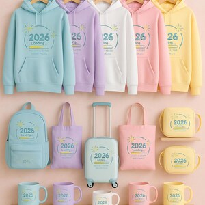 Peut inclure: Ensemble d'articles aux couleurs pastel : sweats &agrave; capuche, sacs &agrave; dos, sacs fourre-tout, valises et mugs. Chaque article affiche le texte "2026 Loading" dans une police fantaisiste. Sur fond rose clair.