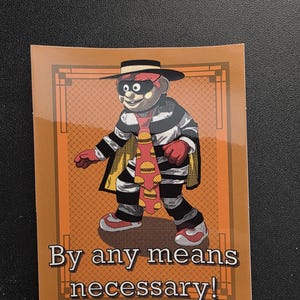 Puede incluir: Una pegatina con una ilustración de dibujos animados de un personaje con un atuendo a rayas blancas y negras, guantes rojos y un sombrero negro. El personaje lleva una corbata con diseños de hamburguesas y una capa amarilla. El texto "By any means necessary!" está en la parte inferior.