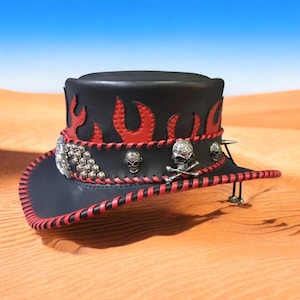 May include: Black leather hat with red flame accents and a red stitched brim. The hat features silver skull and crossbones, skull, and studded embellishments. A stylish accessory for a unique look.
