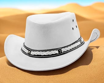 May include: A white cowboy hat with a decorative band featuring a braided design in black and white. The hat has a curved brim and three small air vents on the crown. The hat is set against a desert backdrop.