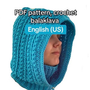 Puede incluir: Primer plano de un pasamontañas de ganchillo azul. El pasamontañas está hecho de un material tejido texturizado y presenta una capucha y una cobertura para el cuello. El texto "PDF pattern, crochet balaclava" y "English (US)" son visibles.