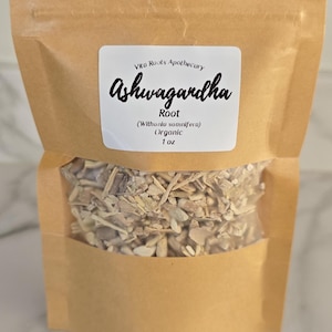 May include: A brown paper bag with a clear window, filled with dried root pieces. A white label displays the text "Vitu Roots Apothecary Ashwagandha Root (Withania somnifera) Organic 1 oz."