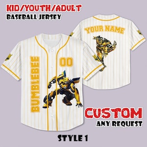 Puede incluir: Camiseta de béisbol blanca con rayas amarillas, con un gráfico de Bumblebee y los textos "BUMBLEBEE" y "00". La parte trasera de la camiseta tiene el texto "YOUR NAME" y un gráfico de Bumblebee. La camiseta está etiquetada como "STYLE 1" y "CUSTOM ANY REQUEST".