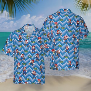 May include: Blue button-down shirt featuring a repeating pattern of the Super Mario character. The shirt has a classic collar and short sleeves. The background is a pixelated blue and white design. The shirt is displayed on a beach setting.
