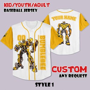 May include: White baseball jersey with yellow sleeves and trim, featuring a yellow and black robot graphic. The jersey has the word "BUMBLEBEE" vertically down the front and the text "YOUR NAME" on the back. The jersey is labeled "STYLE 1".
