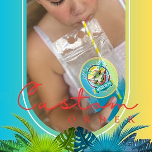 Può includere: Una busta di plastica trasparente piena di liquido blu, sorseggiata attraverso una cannuccia a righe gialle e bianche. La busta ha un'etichetta circolare con una rana in un'amaca e la scritta "MADE IN PR". La parola "Custom Order" è scritta in rosso.