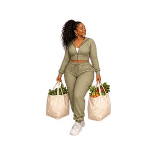 May include: A sage green ribbed two-piece set consisting of a long-sleeve cropped zip-up jacket and matching high-waisted drawstring joggers. The set is worn with white sneakers, and two large beige canvas tote bags filled with fresh produce.