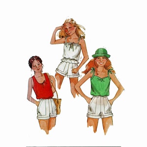 May include: Three girls wearing white shorts and sleeveless tops. The girl on the left is wearing a red top, the girl in the middle is wearing a white top, and the girl on the right is wearing a green top. The girl on the right is also wearing a green hat.