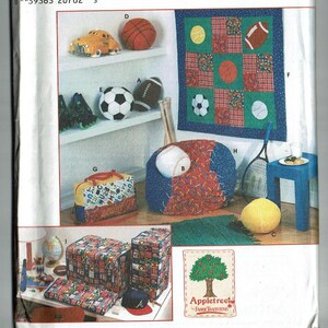 May include: A sewing pattern for a sports-themed room decor set. The pattern includes instructions for making a beanbag chair, a quilt, a storage bin, and other accessories. The pattern is from Appletree Fabric Boutique.
