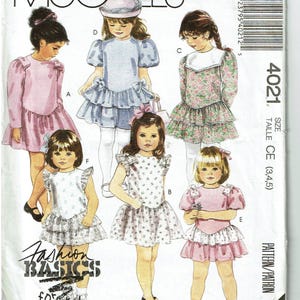 May include: McCall's sewing pattern for children's dresses. The pattern features various dress designs with ruffled skirts, bows, and short sleeves. The cover includes the text "Fashion Basics for Kids."