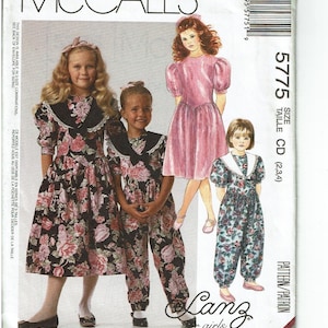 May include: McCall's sewing pattern envelope featuring illustrations of girls' dresses and a jumpsuit. The garments are in floral prints and solid pink. The envelope includes the Lanz girls logo and the size information.