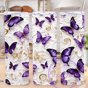 May include: A 20 oz skinny tumbler wrap featuring a white background with embossed floral designs, gold accents, and vibrant purple butterflies. The butterflies vary in size and are scattered across the surface, creating a decorative and eye-catching design.