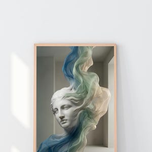 May include: A framed print of a classical bust with flowing fabric in shades of blue, green, and white. The bust is white, and the frame is a light wood colour. The background is a neutral grey.