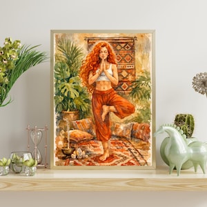 May include: Watercolor print of a woman in a yoga pose, framed in a light wood. The woman has long red hair and is wearing a white top and orange pants. The background includes plants, a rug, and pillows.