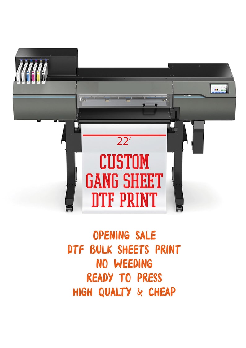 May include: A large format printer with a white banner displaying "CUSTOM GANG SHEET DTF PRINT". The banner is 22 feet wide. The printer is black and gray, with ink cartridges visible on top.