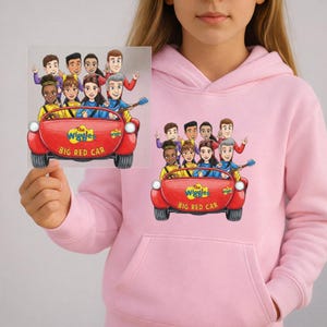 May include: A pale pink hoodie with a graphic of The Wiggles in their Big Red Car. The image shows the band members in a red car with the text "The Wiggles BIG RED CAR".