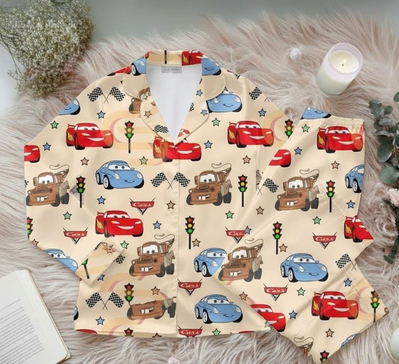 Zoom into dreamland with this Cars Satin Pajama Set, featuring Lightning McQueen, Mater, and Sally against a playful beige racing backdrop. Perfect for Pixar fans, kids, and parents who love cozy, matching sleepwear with a fun race day vibe 🏆🚗💨