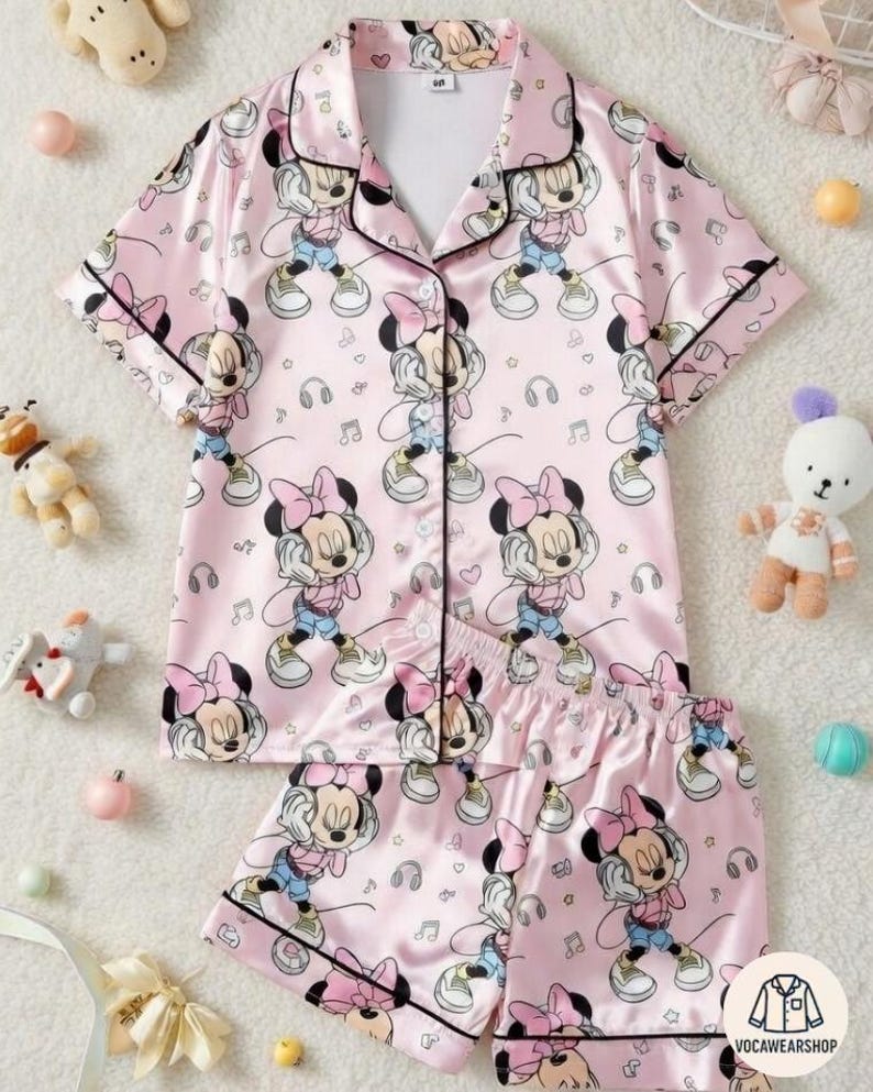 Turn bedtime into Minnie's personal dance party with this super cozy custom pajamas set featuring Minnie Mouse rocking big headphones – dancing with sassy smiles, arms up, surrounded by floating music notes, colorful swirls, hearts & stars on a soft pastel pink background – pure girly, musical Disney joy perfect for family matching, Disney movie nights, kids' bedtime stories, or repping your inner "Minnie DJ" energy!