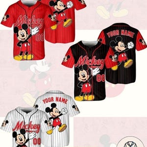 Puede incluir: Camisetas estilo béisbol con Mickey Mouse en rojo, negro y blanco. Cada camiseta tiene el nombre "Mickey" y el número "00" en la parte delantera. La parte trasera de las camisetas tiene el texto "YOUR NAME". Las camisetas están disponibles en tallas para niños, jóvenes y adultos.