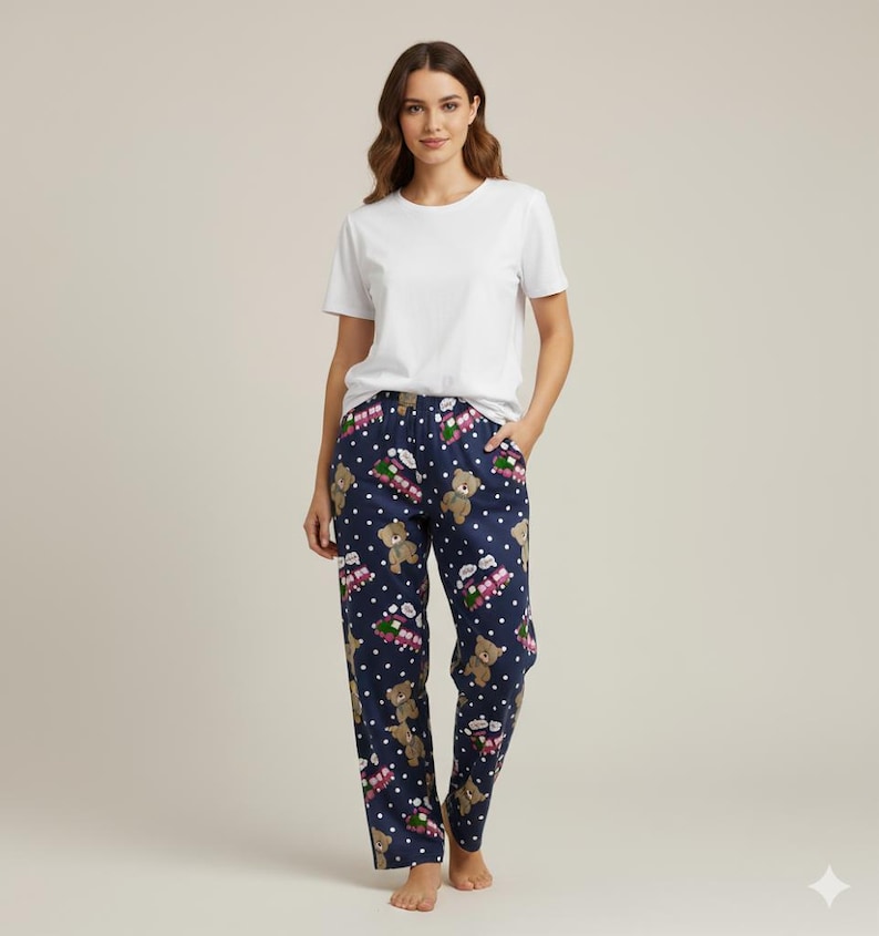 Cute navy pajama pants featuring an all-over print of teddy bears, pink toy trains with “rumi Choo Choo” text, and playful white polka dots. Made from soft, lightweight fabric, these pants are perfect for cozy loungewear or bedtime comfort.