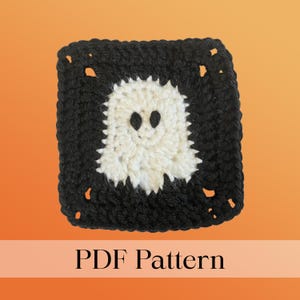 Op de afbeelding: Een vierkant gehaakt item met een zwarte rand en een wit spookontwerp in het midden. Het spook heeft twee zwarte ogen. De woorden "PDF Pattern" staan onderaan de afbeelding.