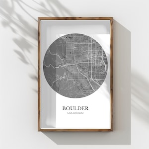 Könnte beinhalten: Gerahmte Graustufenkarte von Boulder, Colorado. Die kreisförmige Karte zeigt detaillierte Straßen- und Geländemerkmale. Der Stadtname und der Bundesstaat sind in einer modernen Schriftart darunter gedruckt. Der Rahmen hat eine warme braune Farbe.