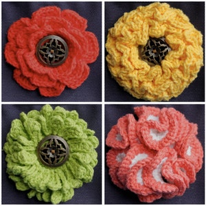 May include: Four crocheted flower embellishments with a metal button center. The flowers are in red, yellow, green, and pink.